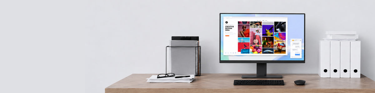 LG 24BA750 monitor displaying a creative design gallery webpage on a wooden desk setup.
